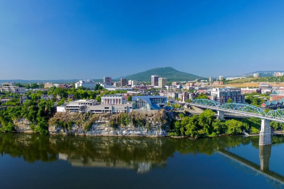 Aerial view of Chattanooga, Tennessee with blue bridge over river in foreground.